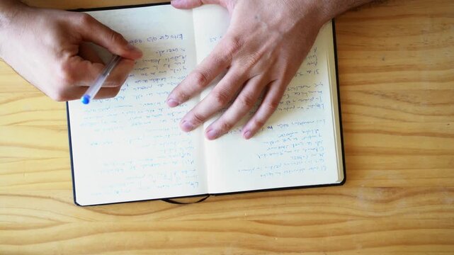  Top view shot of hands writing in notebook