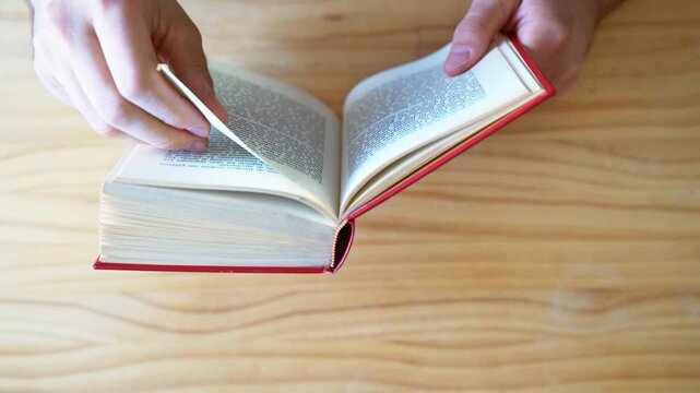 Top view shot of hands scrolling through book pages fast