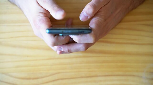 Phone addiction. Infinite scrolling. Doomscrolling. Texting. Top view shot of Hands using smartphone