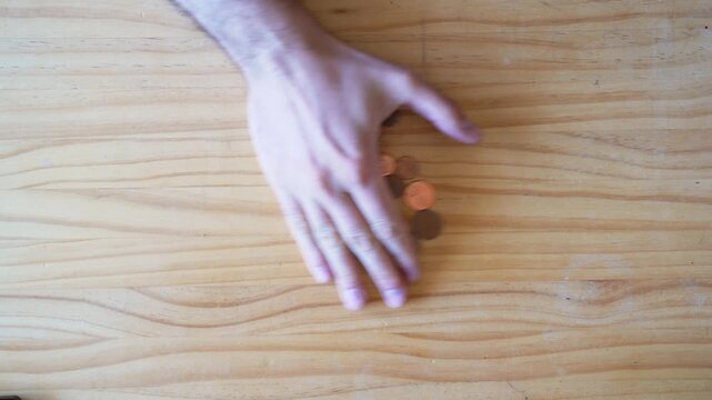 Cash and physical money concept. Stealing and hoarding. Savings. Hand grabbing Coins onver wooden table