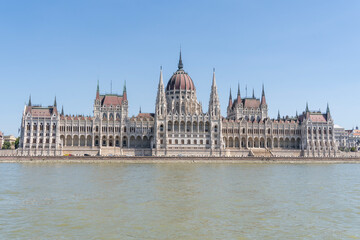 Obraz premium The neo-Gothic building of the Hungarian Parliament on the banks of the Danube in Budapest