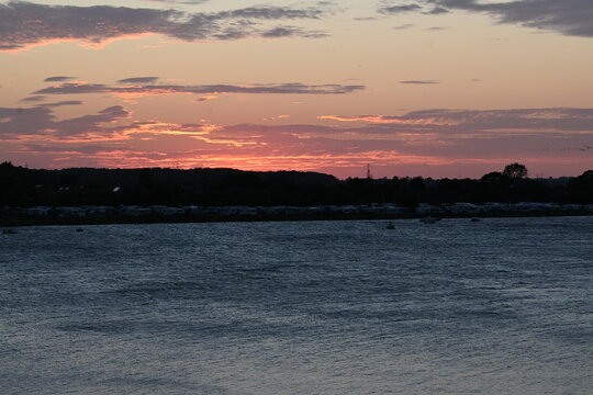 Fiery Red Sunset Horizon over Coastal Bay and Camping Site