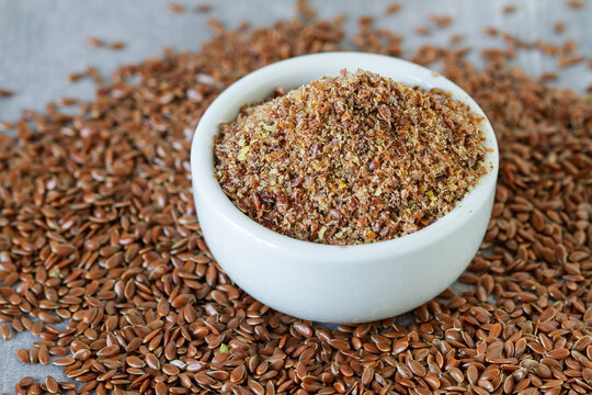 Flax dry seeds, whole and ground on a table