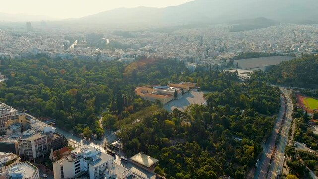 Athens, Greece. Zappeion Hall, neoclassical building with rust-colored facade, central atrium and curved colonnades, Drone footage over the National Gardens. Drone footage, Point of interest