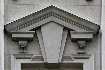 Architectural triangular pediment with decorative keystone on stone building facade © Predrag