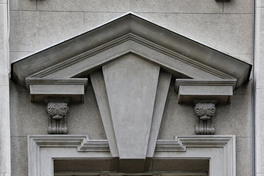 Architectural triangular pediment with decorative keystone on stone building facade
