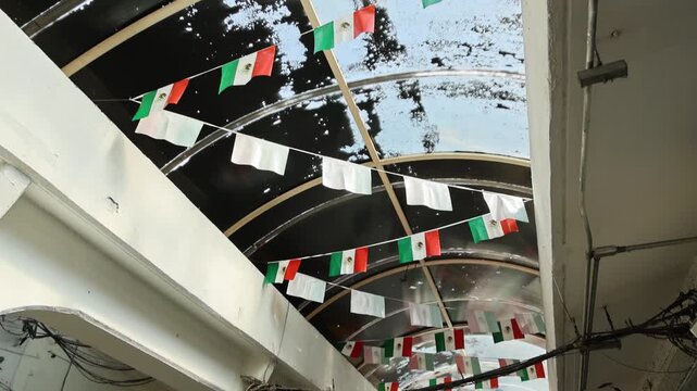 Mexican Flags And White Banner Strings Hanging Under Covered Market Walkway