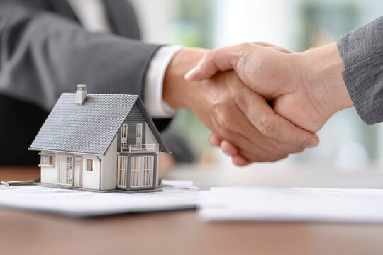 Shake hand Real estate brokerage agent Deliver a sample of a model house to the customer, mortgage loan agreement Making lease and buy and sell house And contract home insurance mortgage loan concept 
