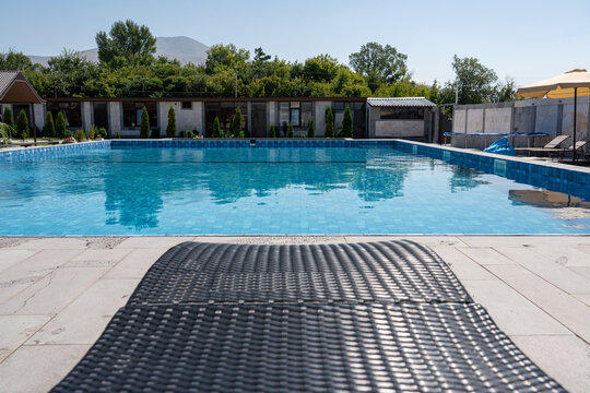 Luxury Outdoor Swimming Pool with Sun Loungers in Modern Resort.