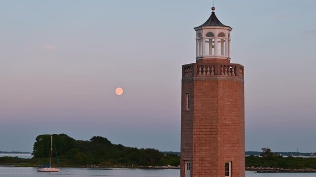 Groton, Connecticut, USA &ndash; Full Sturgeon Moon Beside Avery Point Lighthouse at Blue Hour