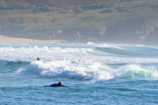 Surfers amidst powerful waves and water mist at Doni&ntilde;os Beach, Ferrol , Spain ,
May 18 , 2026