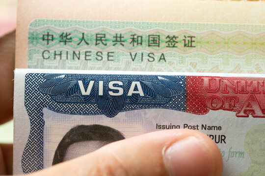 Both a China visa and a United States visa inside open passport pages. Ideal image for international relations, global travel, diplomatic affairs, trade, travel permits, and immigration topics.