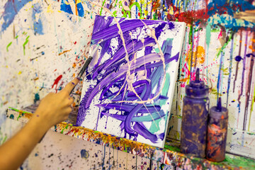Artist painting abstract canvas in messy art studio © Zsolt Biczó
