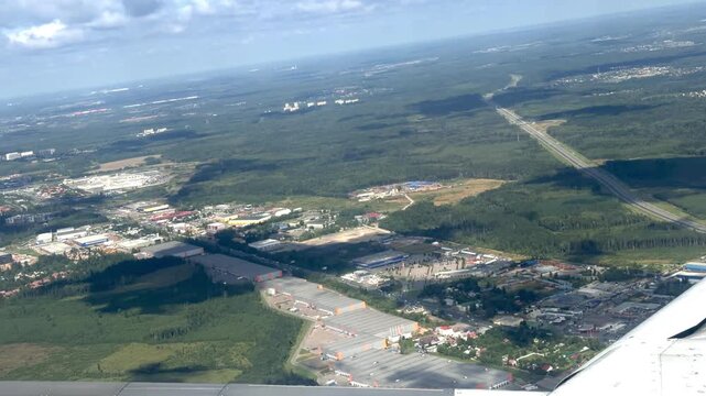 Aerial perspective captures urban development alongside forests and highways, illustrating the blend of industrial zones and natural landscapes