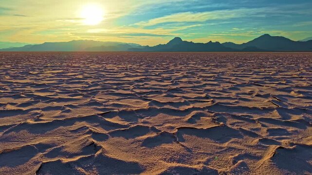 Aerial view of golden sunset light highlighting hexagonal crust patterns across Bonneville Salt Flats in Utah
