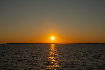 Obraz premium the water surface of a river or lake with sun glare at sunset
