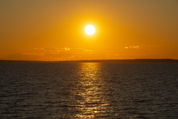 Obraz premium the water surface of a river or lake with sun glare at sunset