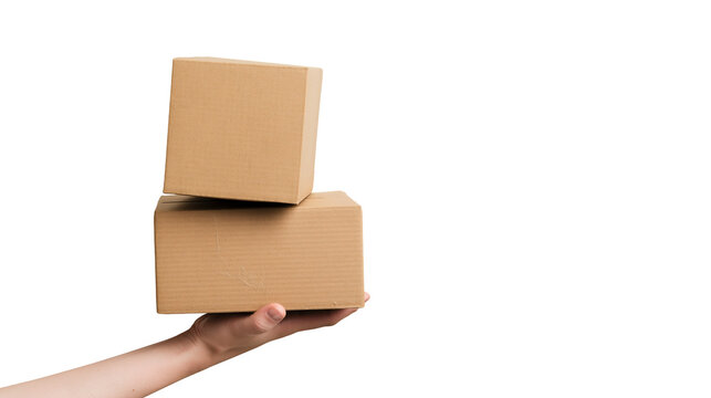 Isolated human hand holding two small stacked brown cardboard boxes for shipping and delivery.