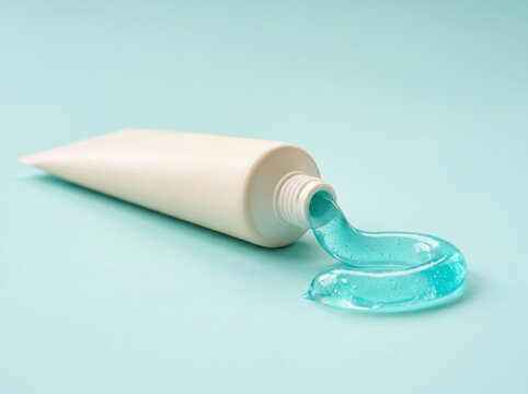 Blue gel toothpaste squeezing from tube on pastel background