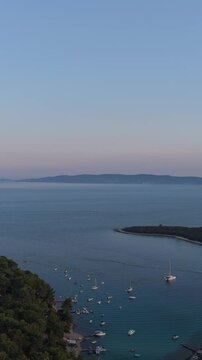 FKK Naturist Baldarin Campsite In Punta Kriza On Cres Island, Croatia, Filmed By Drone During A Beautiful Summer Evening. Aerial Views Show Campervans, Motorhomes, Coastal Nature at Sunset