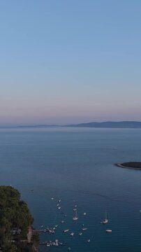 FKK Naturist Baldarin Campsite In Punta Kriza On Cres Island, Croatia, Filmed By Drone During A Beautiful Summer Evening. Aerial Views Show Campervans, Motorhomes, Coastal Nature at Sunset