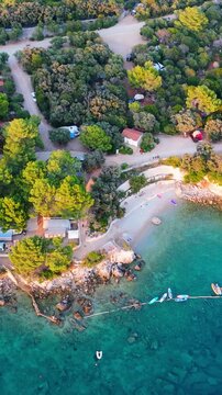 FKK Naturist Baldarin Campsite In Punta Kriza On Cres Island, Croatia, Filmed By Drone During A Beautiful Summer Evening. Aerial Views Show Campervans, Motorhomes, Coastal Nature at Sunset