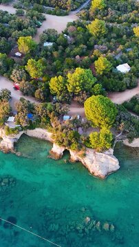 FKK Naturist Baldarin Campsite In Punta Kriza On Cres Island, Croatia, Filmed By Drone During A Beautiful Summer Evening. Aerial Views Show Campervans, Motorhomes, Coastal Nature at Sunset