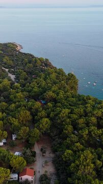 FKK Naturist Baldarin Campsite In Punta Kriza On Cres Island, Croatia, Filmed By Drone During A Beautiful Summer Evening. Aerial Views Show Campervans, Motorhomes, Coastal Nature at Sunset