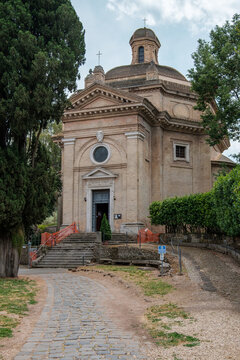 Exterior view of the Church of Santa Maria Scala Coeli with its dome and cobblestone path at Tre Fontane Abbey in Rome Italy
