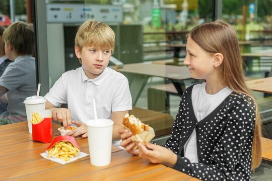 Brother and Sister Eating Burger and Fries Together