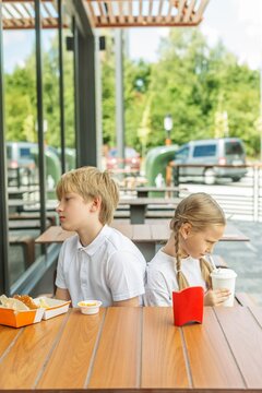 Offended siblings sitting apart during fast food meal
