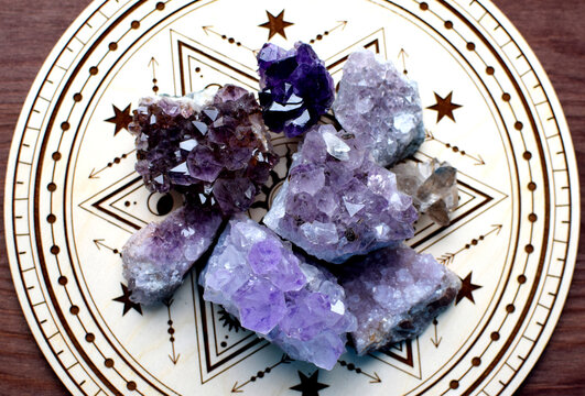 Beautiful natural amethyst druze on a wooden altar for divination. Fortune telling, witchcraft, and esoteric spiritual practices.
