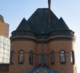 Historic brick building facade featuring two rounded turrets and a dark slate roof © 4kclips