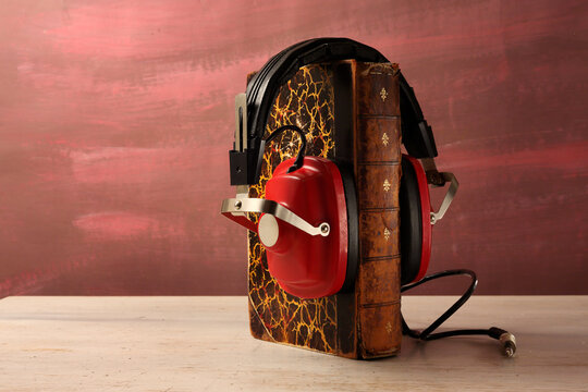 audiobooks concept with old books and vintage headphones colored  background