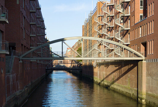 Speicherstadt canal flowing between brick buildings with bridges overhead