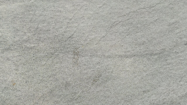 A minimalist textured background of light gray concrete with subtle, linear imperfections and a very faint, organic pattern