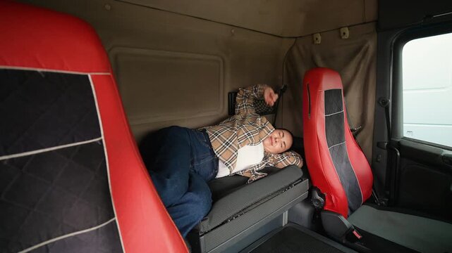 Female truck driver waking up in sleeper cabin