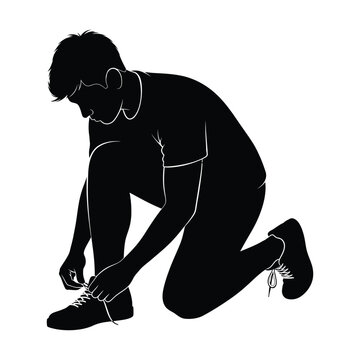 Young man kneels on the floor while tying his shoelaces in a side profile.