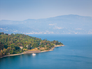 Naklejka premium Aerial drone panoramic view of Lake Maggiore in northern Italy, showcasing the expansive alpine lake, surrounding mountains and picturesque lakeside landscape