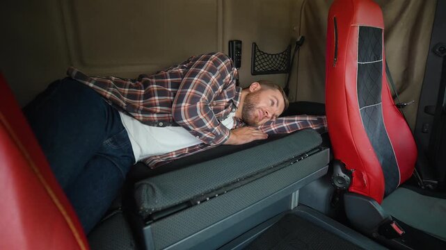 Tired truck driver waking up in the sleeper cabin