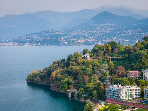 Aerial drone panoramic view of Lake Maggiore in northern Italy, showcasing the expansive alpine lake, surrounding mountains and picturesque lakeside landscape