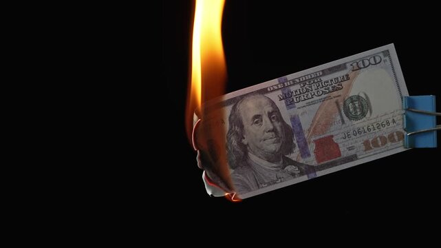 Burning dollar banknotes in fire on black background