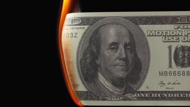 Burning dollar banknotes in fire on black background