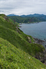日本　北海道積丹町・神威岬の緑豊かな斜面から見下ろす積丹半島の海岸線 © pespiero