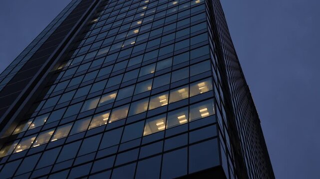 Tall office building facade with some room with light at night