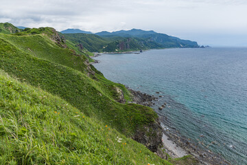日本　北海道積丹町・神威岬の緑豊かな斜面から見下ろす積丹半島の海岸線 © pespiero