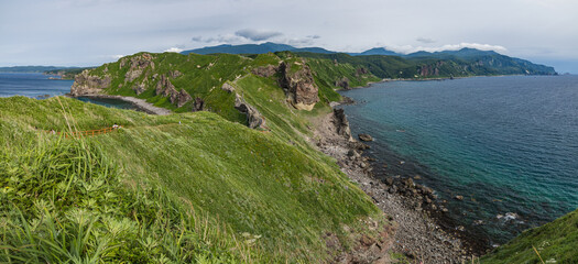 日本　北海道積丹町・神威岬の美しい笹原の尾根とコバルトブルーに輝く日本海 © pespiero