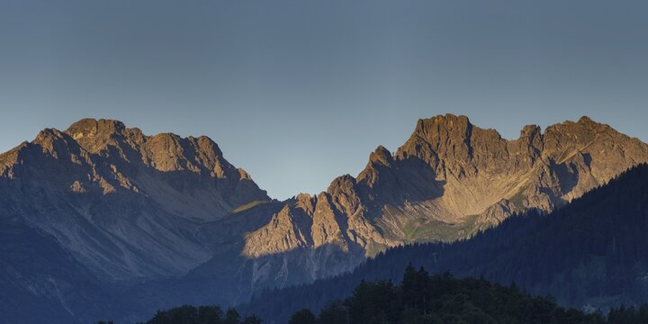 Mountain panorama at sunrise from Stillachtal into Warrmatsgundtal, left Alpgundkopf, Rossgundkopf and Griesgundkopf, right Sch&uuml;sser, 2259m, and Hochgehrenspitze, 2251m, Allg&auml;u Alps, Bavaria, Germany