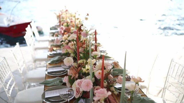 Stylish oceanfront dining arrangement with flowers and warm light
