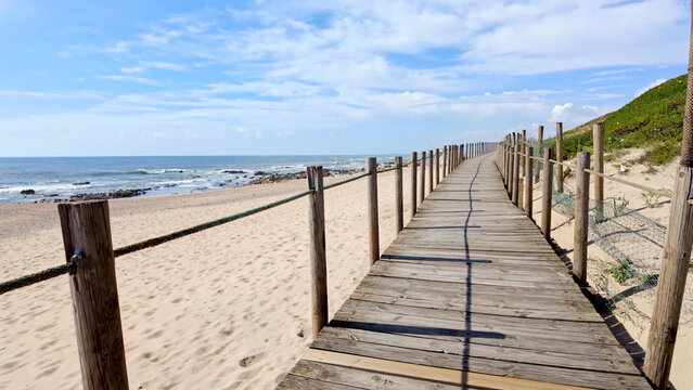 Wooden Boardwalk Leading Along the Sandy Coastline of Miramar Beach in Portugal